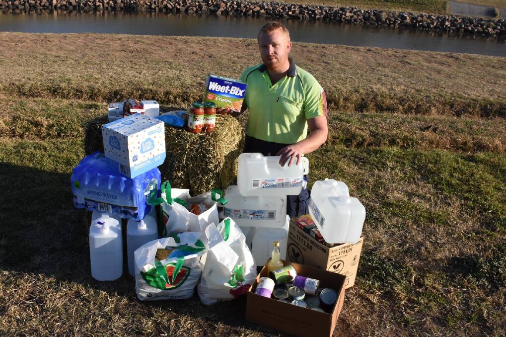 Helping hand: Issac Delalande with some of the supplies that were taken to drought-stricken Coonabarabran farmers over the weekend. 