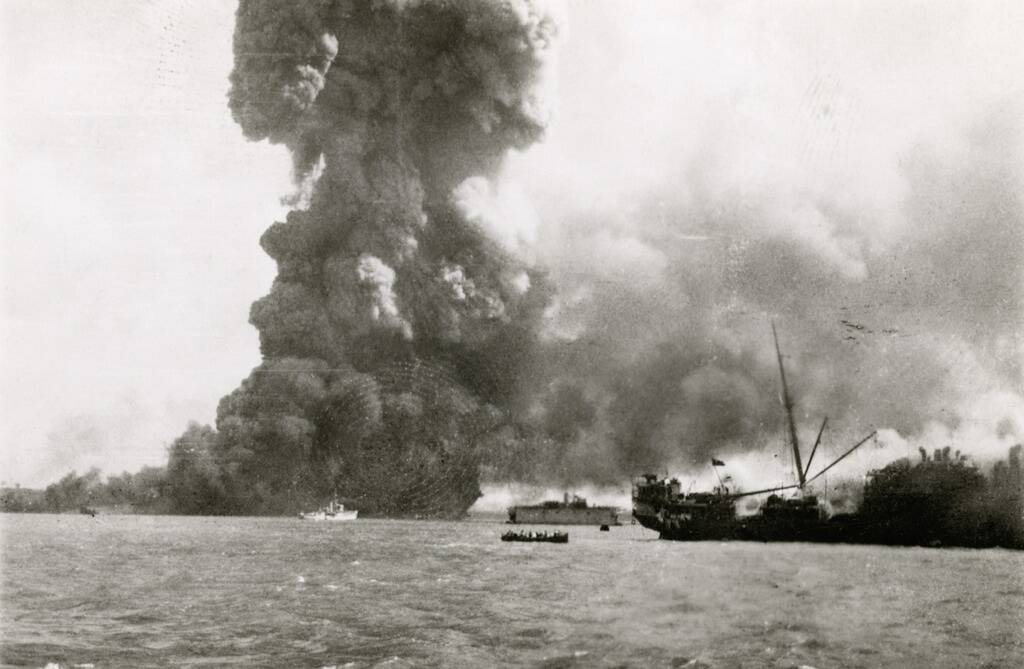 ON FIRE: Darwin Harbour on February 19, 1942. Photo: Australian War Memorial
