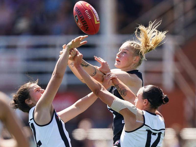 Tayla Harris (c) of the Blues competes for the ball against Magpie Stacey Livingstone (r) on Sunday.
