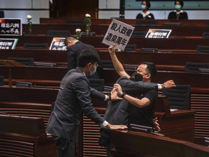 Pro-democracy law maker Chan Chi-chuen scuffles with security guards in Hong Kong's law chamber.