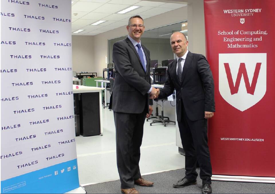 Thales Australia's Mike Rigby and Western Sydney University's Professor Simeon Simoff celebrate the signing of an agreement. Picture: SUPPLIED. 