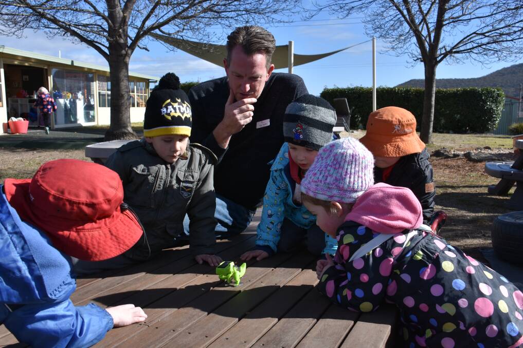 LEARNING ABOUT THE WORLD: It's to know who is more excited by this solar-powered dinosaur - the students of Pied Piper Preschool or its director, Luke Touhill. 