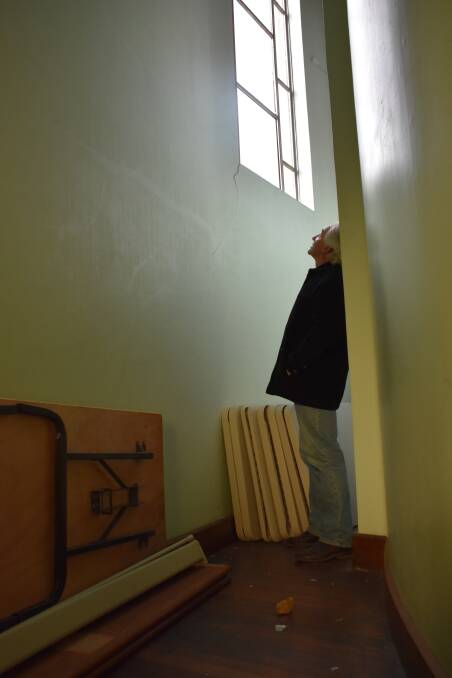 Lithgow Baptist Church secretary Grahame Edgell surveys some of the damage from a window smashed on Saturday, July 14. 