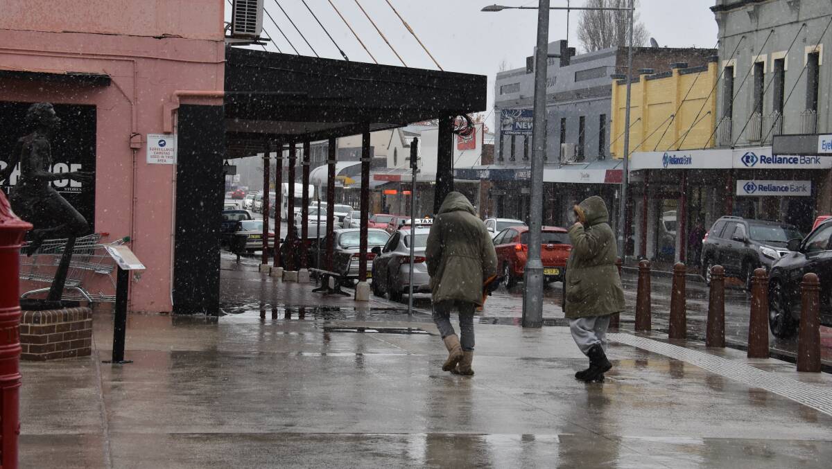 Visitors rug up against the snow on Lithgow's Main Street. 