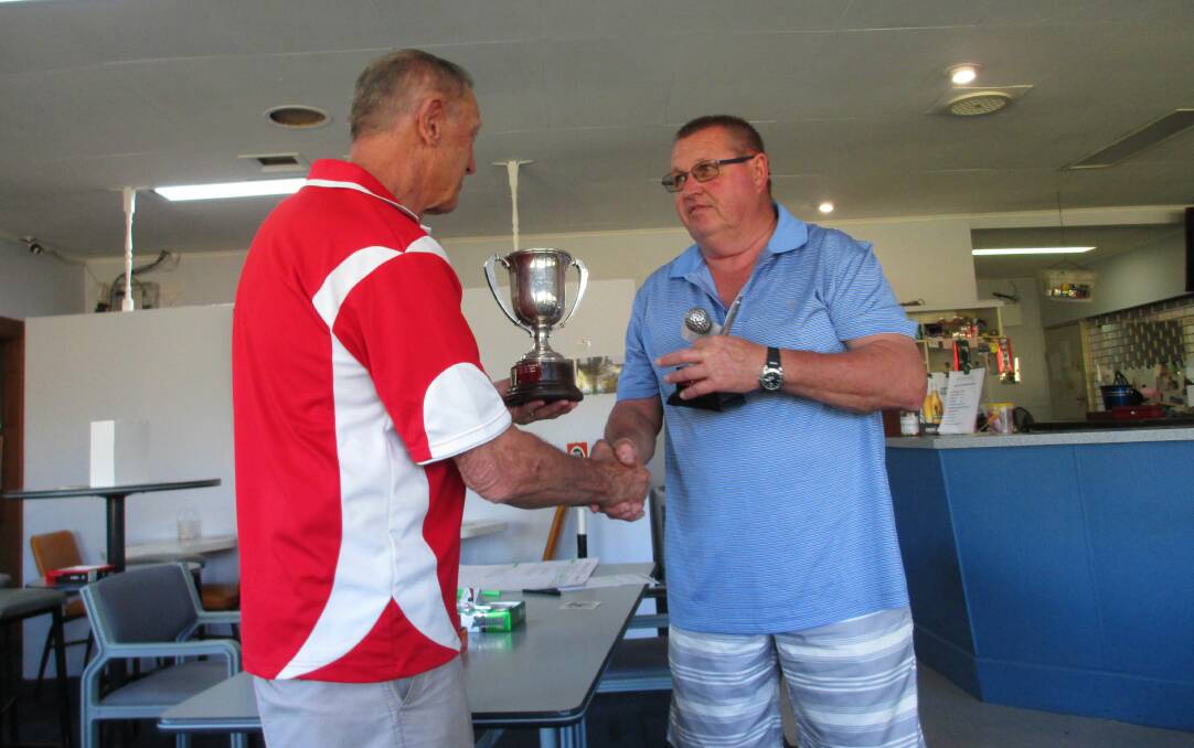 WINNER: Dave Hampson accepts the A grade trophy from Portland Golf Club president Bob Roberts. 