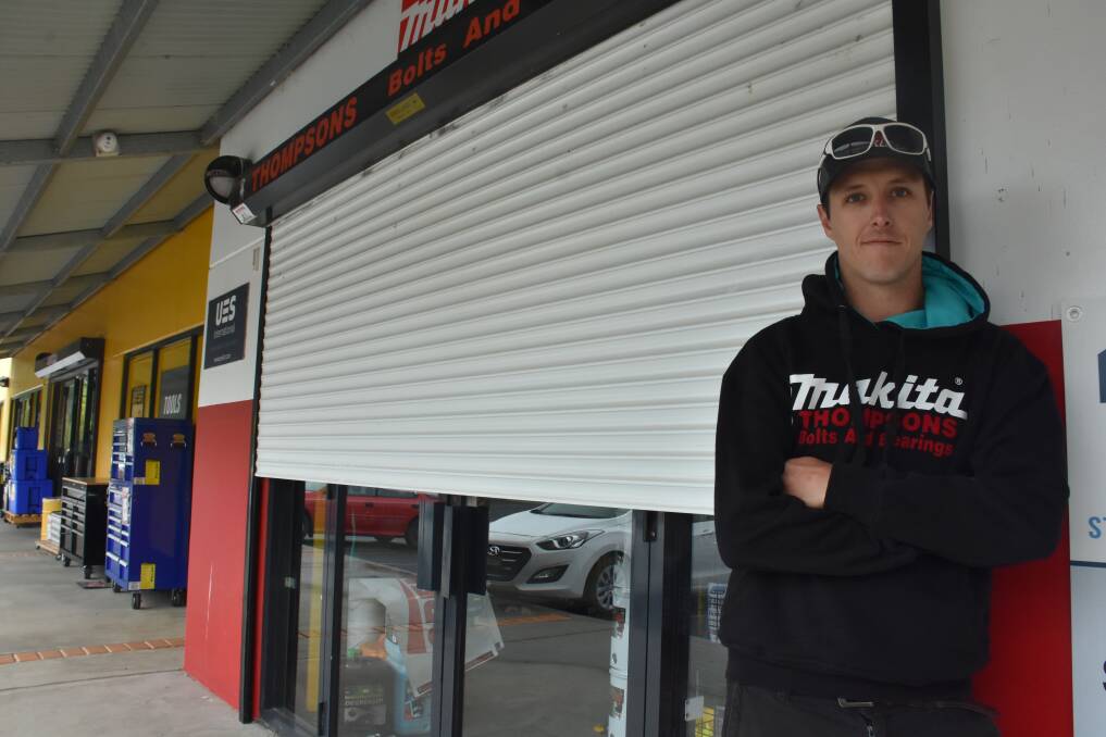 RIPPED IN HALF: Owner Daniel Thompson with the roller door at Thompsons Bolts and Bearings after the Wednesday morning break in. Picture: KIRSTY HORTON. 