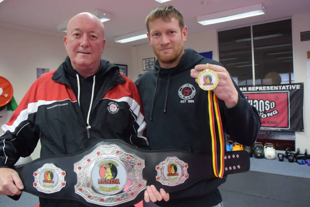 READY: Australian coach Rob Williams with the belt Mitch Vanderhaar will be competing for in October. Vanderhaar holds his gold medal from Port Macquarie. Picture: KIRSTY HORTON. 