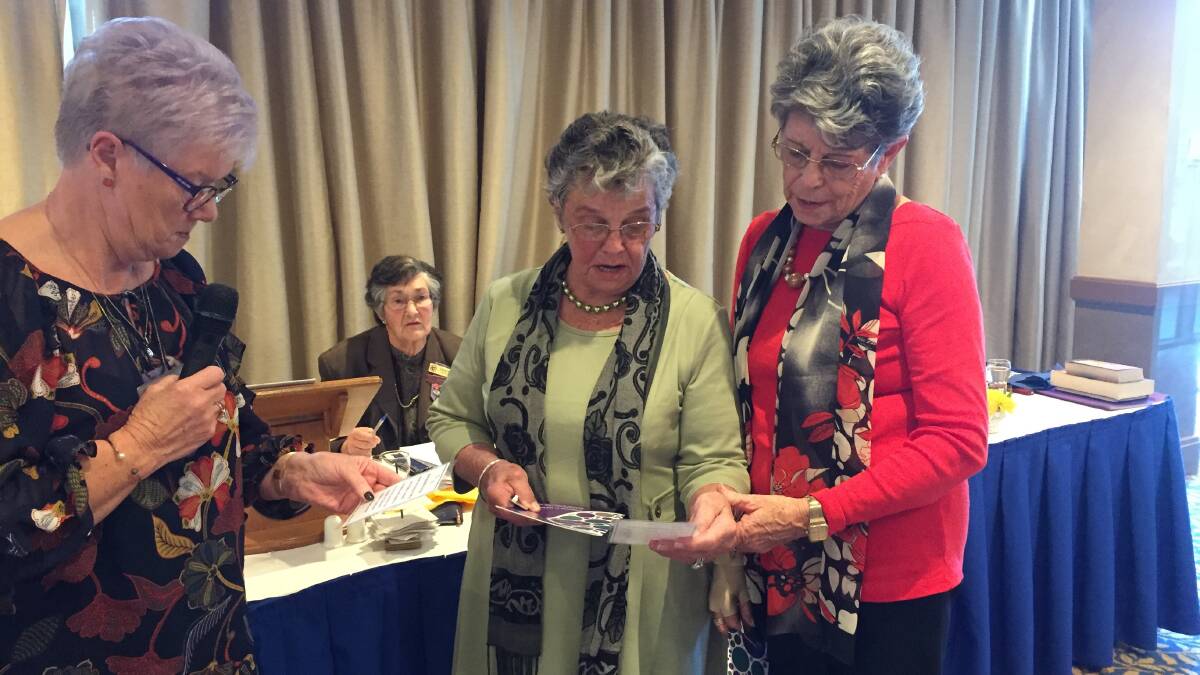 President Sue Giokaris and new members Jill Thomas and Beryl Riley read the pledge. 