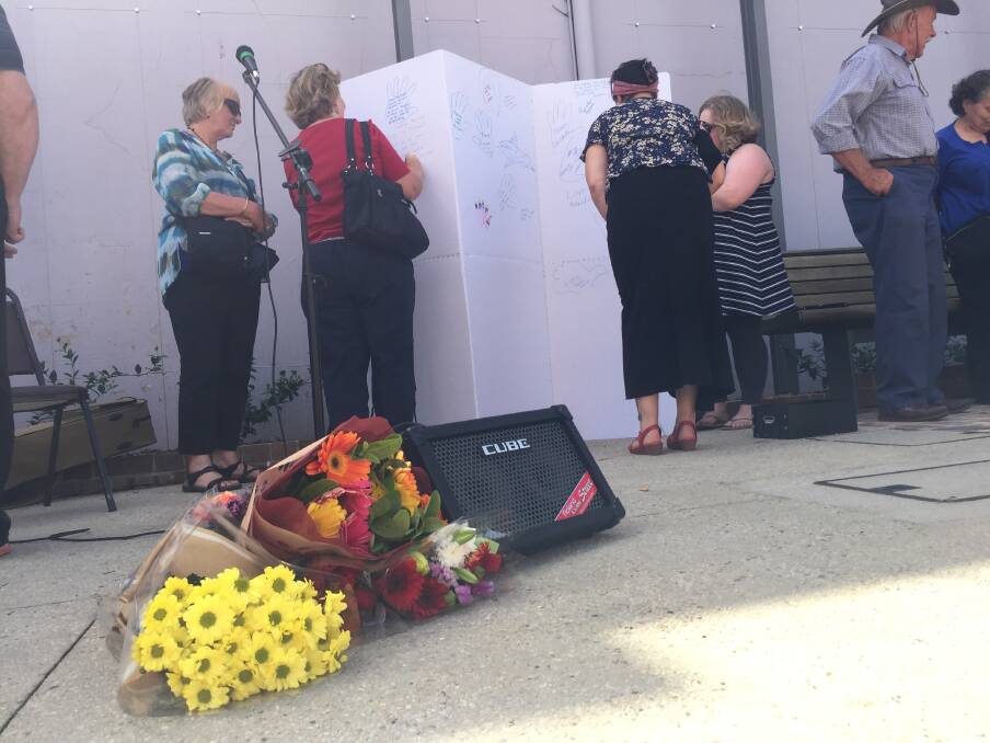 SUPPORT: People add their messages to the wall, while others lay flowers for the victims of the Christchurch massacre. 
