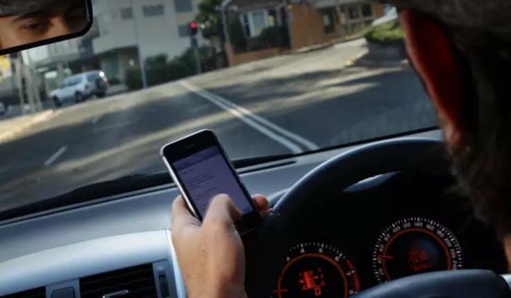 GET YOUR HAND OFF IT: An extra demerit point for mobile phone offences is making a difference, police say. Photo: KEN ROBERTSON