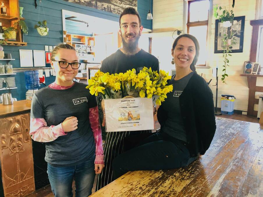 DAFFODIL DAY: The Tin Shed employees Codie, Patrick and Amy with the bright, yellow bunches. Photo: SUPPLIED.