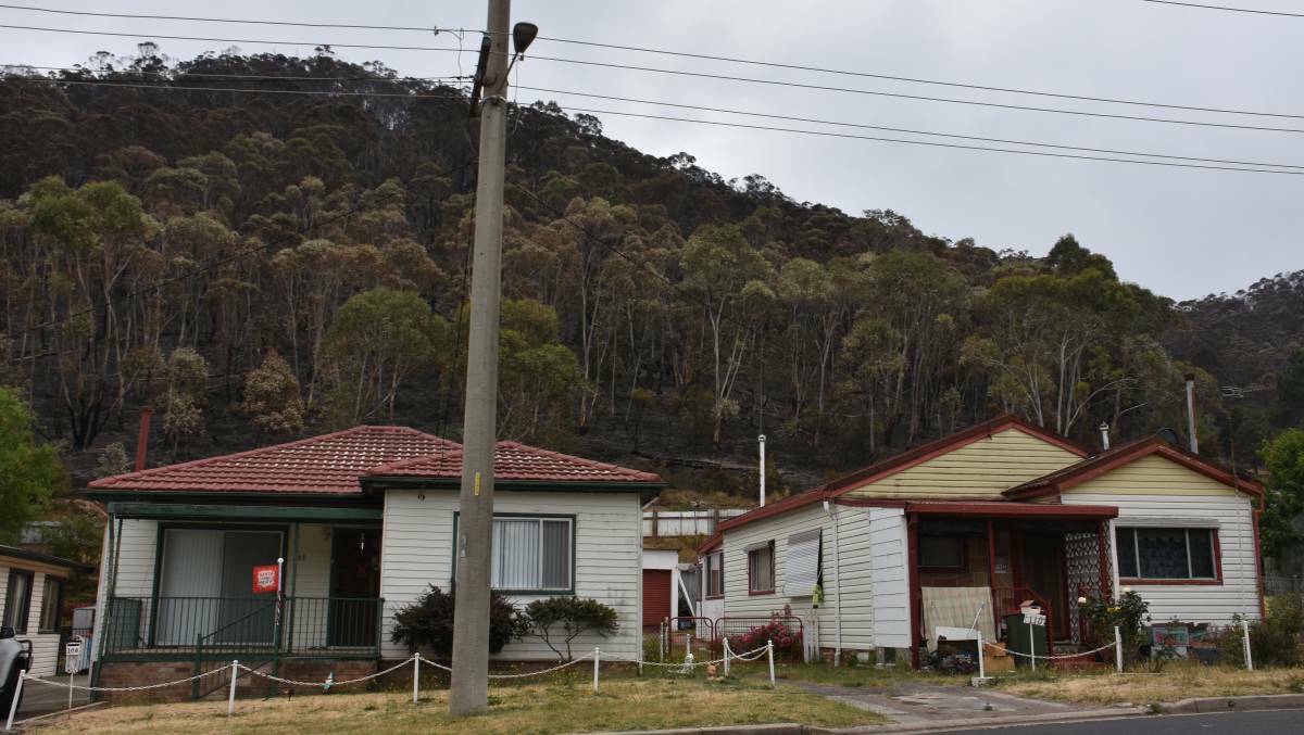 CLOSE TO HOME: The burnt hill behind houses on McAuley Street. Picture: ALANNA TOMAZIN.