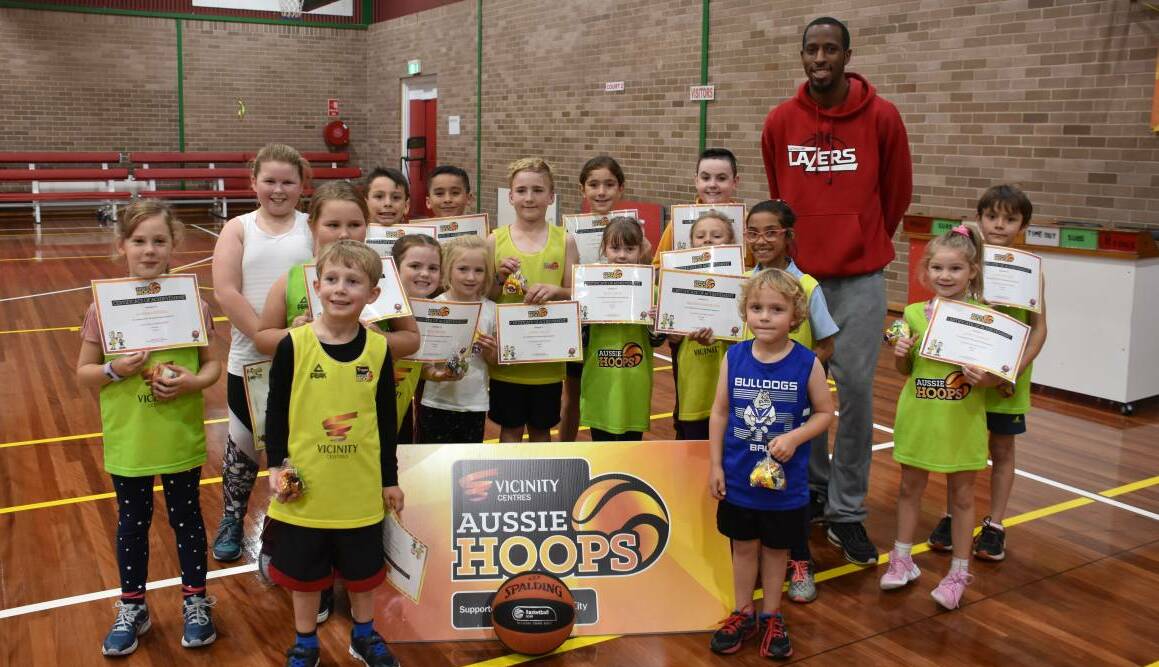DRIBBLING SUCCESS: The Aussie Hoops kids with Lazers import Michael Johnson. Picture: CIARA BASTOW.