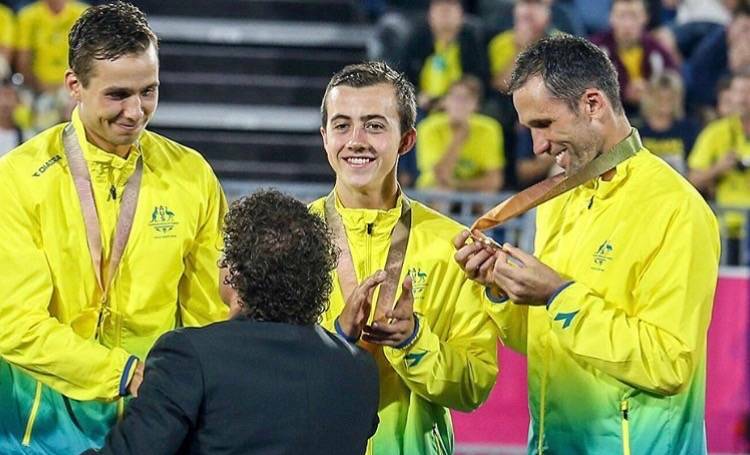 GOLDEN GLOW: Lachi Sharp (centre) proudly showcases his Commonwealth games gold medal with his Kookaburras teammates Mark Knowles (right) and Tom Craig. Photo: SUPPLIED
