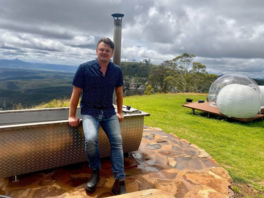 WOW: Bubbletent Australia company director Sonny Vrebac sits on the edge of a Swedish wood-fired bathtub with bubbletent Virgo in the background. Picture: ALANNA TOMAZIN