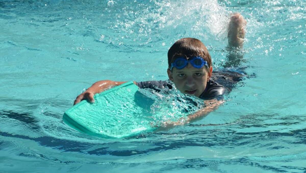 Adam Andersen having a splash on the paddle board at the community pool, Port Pirie, South Australia.