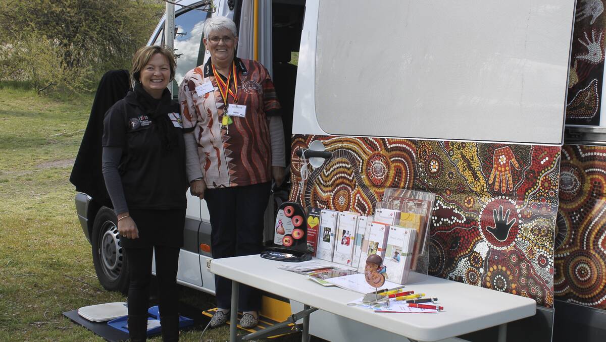 HITTING THE BITUMEN FOR HEALTH: Veronica Lloyd (left) and Helen Riley spread the word about the Mootant Tarimi health screening bus at Lithgow’s NAIDOC Week. 	lm092613van