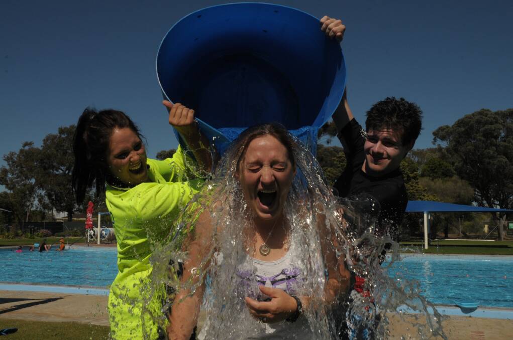 Bordertown District Memorial Pool manager Laura Nash gets soaked by lifeguard Haylee Rodert and Vacswim instructor in training Tyler Campbell at Bordertown, South Australia.