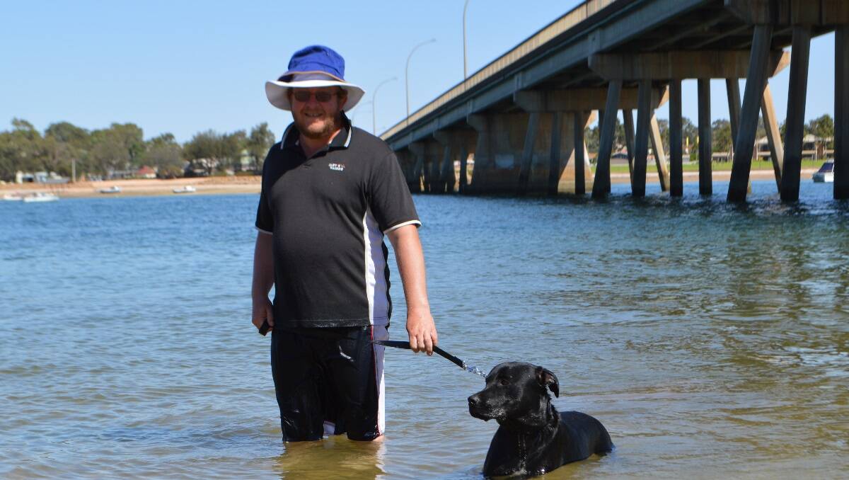 Joe Tate takes his pooch for a dip to stay cool at Port Augusta, South Australia.